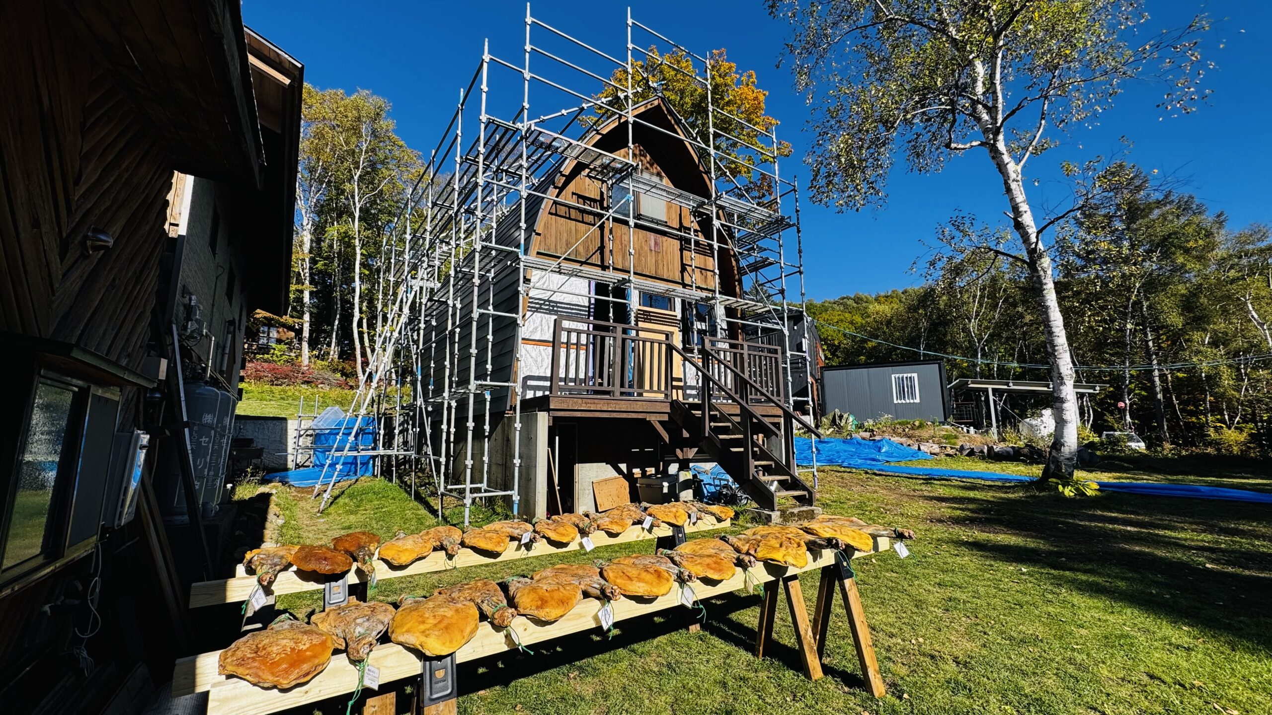 峰の原高原の屋外でAs Neco Hamの生ハムを天日干しする風景